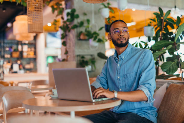 istock Young man sitting in coffee shop and using laptop 2163495423