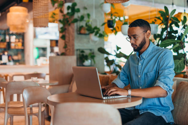 istock Young man sitting in coffee shop and using laptop 2163495429