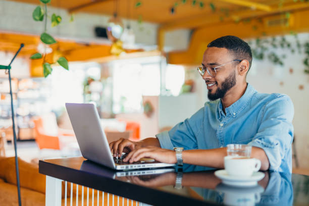 istock Young man sitting in coffee shop and using laptop 2163495639
