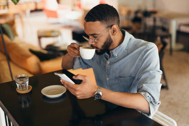 istock Young business man texting on his phone at a cafe 2163495832