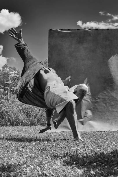 Men dancing outdoors. Male break dancer dancing against nature and studio background. Hip-hop dancer in a nature. Shallow depth of field. Toned image, Black and White photo .