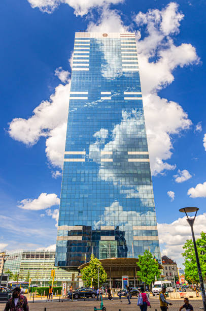 Brussels, Belgium, July 6, 2023: South Tower or Pensions Tower skyscraper modernism architecture style modern office building reflecting white clouds in blue sky in Brussels city