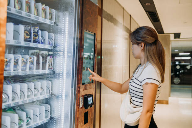 istock Convenient Choices: Asian Woman Using Modern Vending Machine for Food and Drink 2163502600