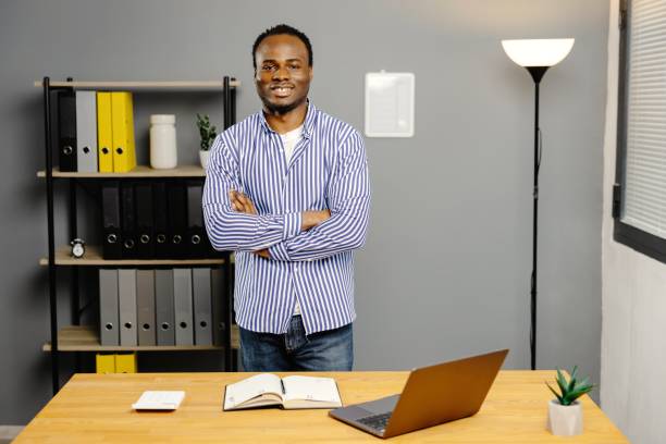 istock Man standing in front of desk with laptop 2163504355