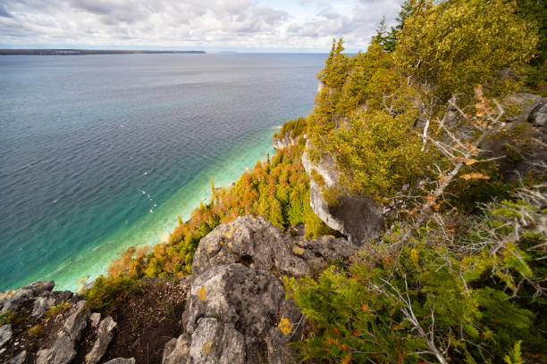 istock Lake Huron turquoise waterfront surrounded by Limestone Rocky Cliffs with Trees, autumn day landscape 2163506229