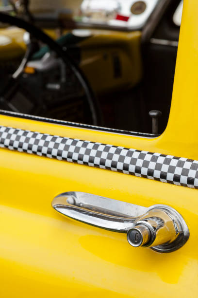 Bobblehead dachshund between covered toilet paper rolls on the parcel shelf in a vintage car, in Germany called Wackeldackel, popular in the 1960s and 1970s, copy space, selected focus