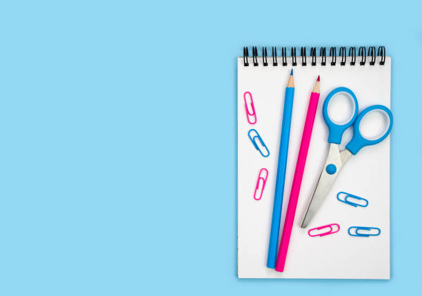 istock Flatlay composition with notebook, pencils and scissors on a blue background. Back to school. Banner. Top view. Place for text. 2163506970