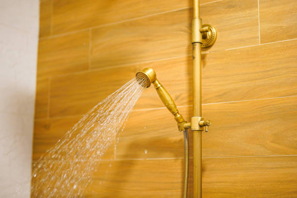 Water falling from luxury classic designed rain shower head that made from brass-alloy material. Interior household furniture object, close-up and selective.