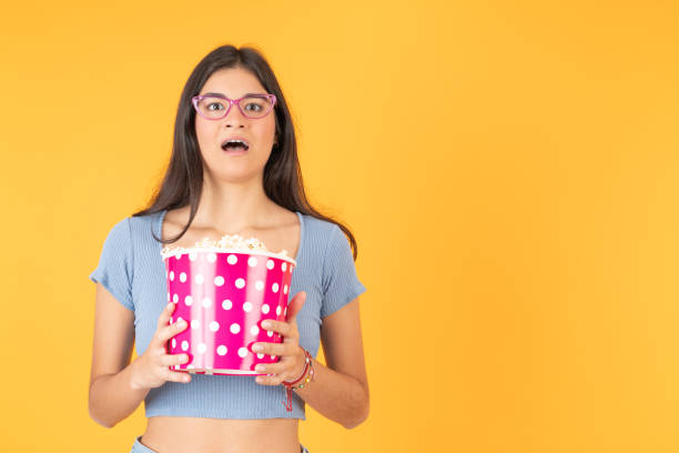 istock Woman with a terrified expression holding a bag of popcorn 2163507183