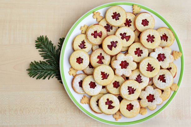 Linzer cookies on a plate, with fir twig around it