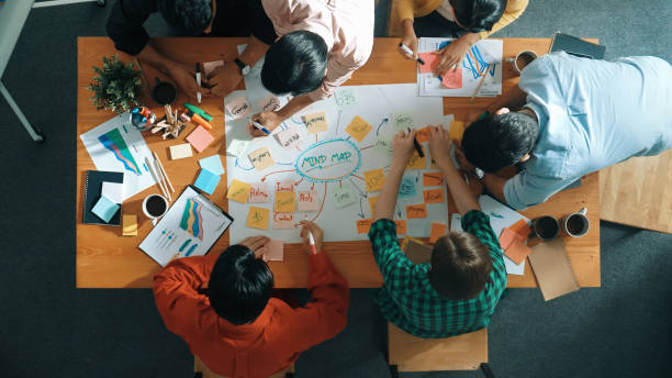 istock Group of business people writing and making mind map at meeting. Convocation. 2163508982