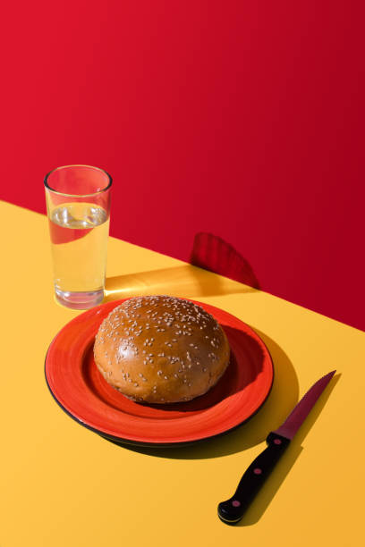 istock A hamburger bun, glass with water and knife. 2163510713