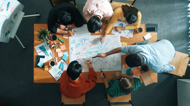 istock Group of business people writing and making mind map at meeting. Convocation. 2163515220