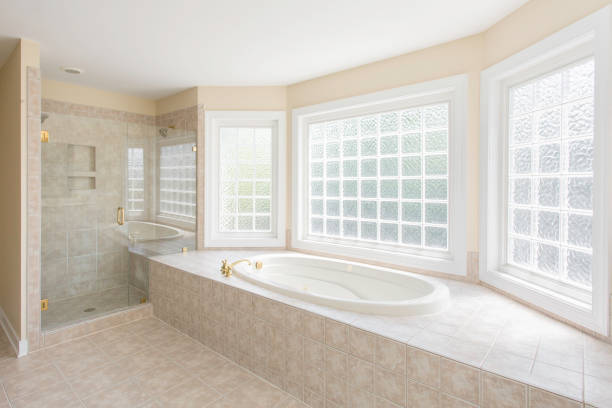 This bathroom has a brick decor bathtub.  A walk in shower stall.