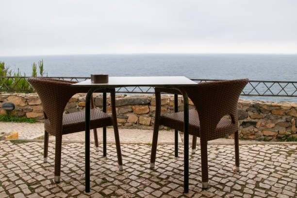 istock Table and chairs on a terrace with the sea in the background 2163515531