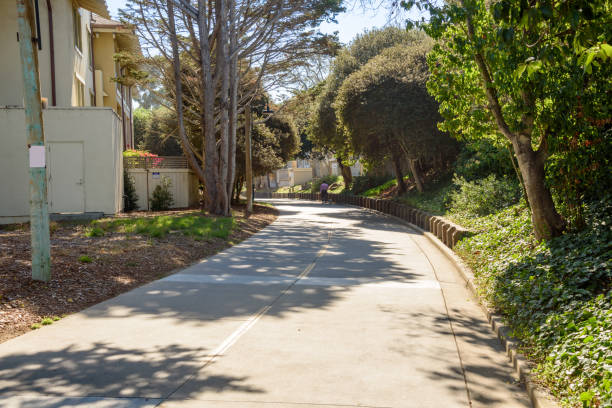 istock Large paved path through a residential district on a sunny fall day 2163515584