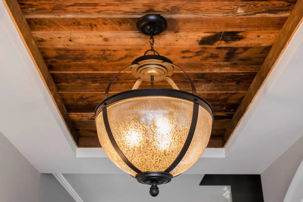 Rustic Ceiling Light Fixture In A Home With A Wooden Ceiling Detail.