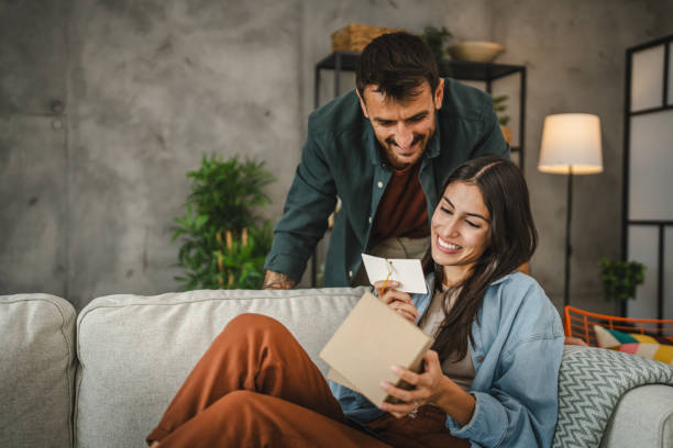 istock Girlfriend read greeting card thank you note from his boyfriend 2163517753