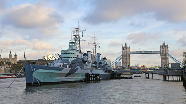 London, United Kingdom - November 23, 2013: HMS Belfast Royal Navy War Museum at River Thames and Tower Bridge in Capital City Cloudy Winter Day.