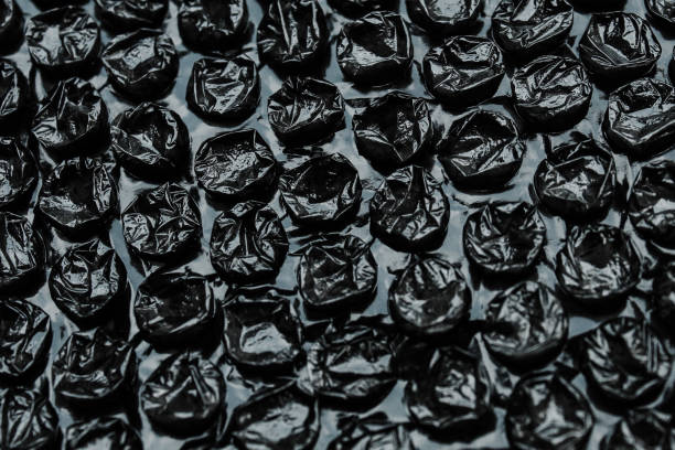 istock Black bubble plastic wrap surface texture.   plastic with air balls on the surface is used to package fragile items or electronic items or sensitive items 2163523413
