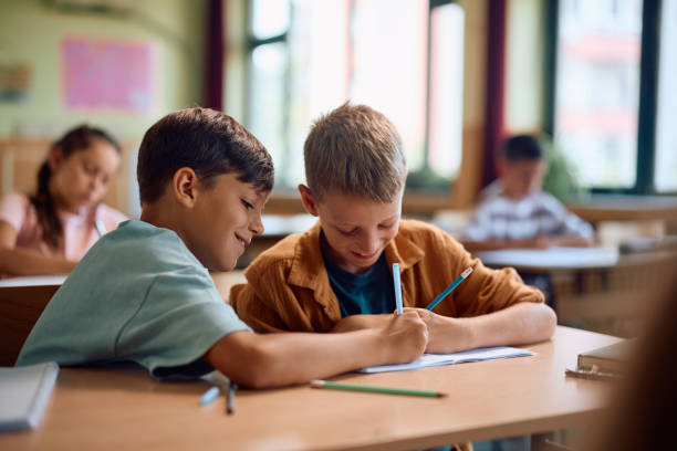 istock Happy schoolboys learning together in the classroom. 2163524034