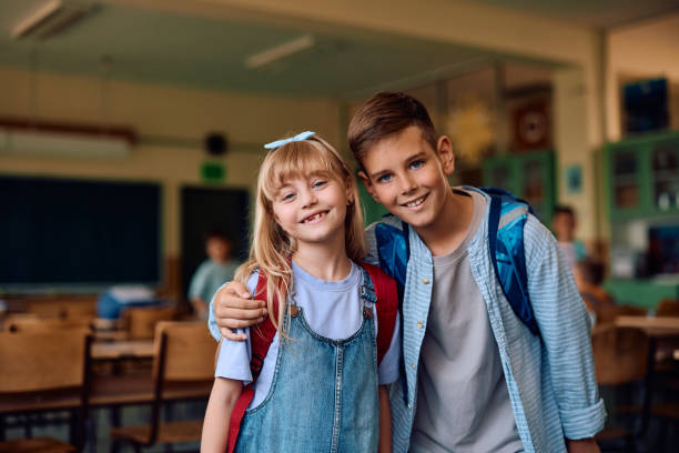 istock Happy elementary school classmates in the classroom looking at camera. 2163524091