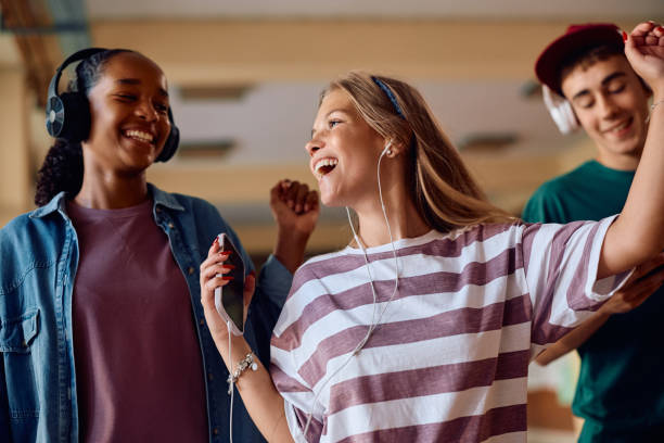 istock Cheerful student having fun while listening music at high school. 2163524690
