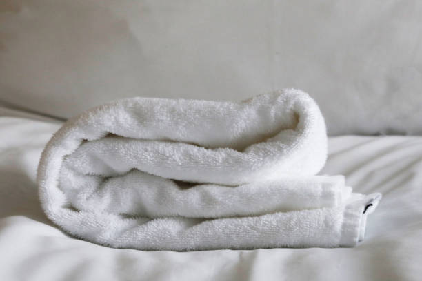istock White folded terry towels on a white sheet. 2163526641
