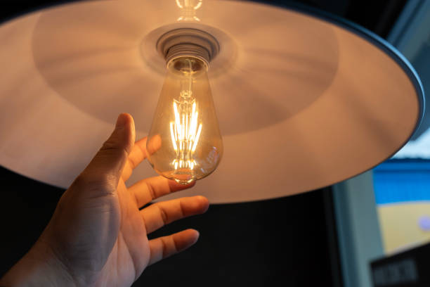 istock Woman's hands changing light bulb. A hand reaching for conceptual idea lightbulbs. 2163532880