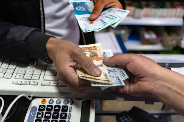 Man's hands with Colombian coins and bills