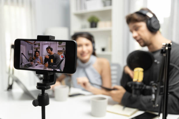 istock Focus on smartphone recording with blurry host channel broadcaster. Postulate. 2163537409