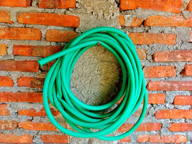 istock roll of green rubber water hose hangs on a brick wall 2163541924