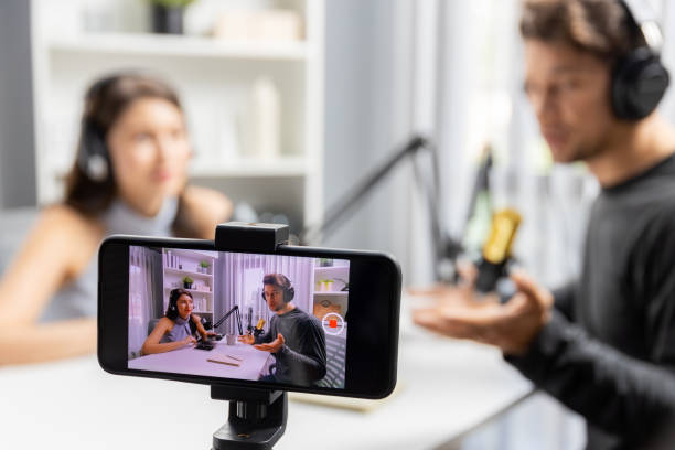 istock Focus on smartphone recording with blurry host channel broadcaster. Postulate. 2163542876