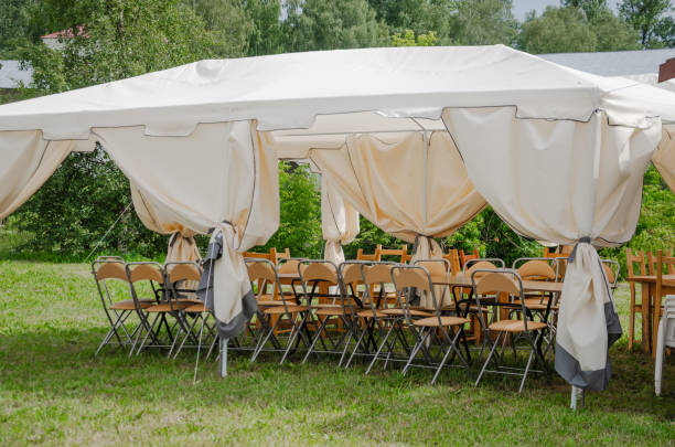 Summer tent with chairs stacked outside for celebration