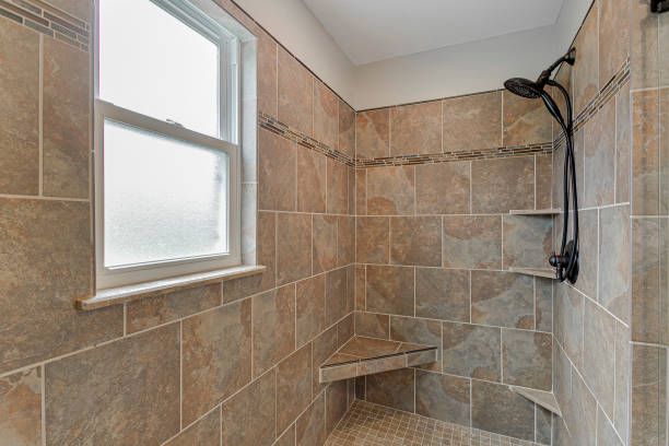 istock Stone-Tiled Shower With A Seating Area And Black Showerhead Under Natural Light. 2163548287