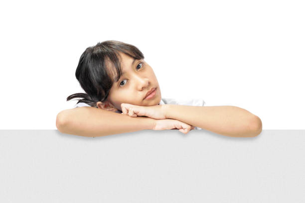 A girl is looking through a white board. The girl is wearing a white shirt and a blue tie