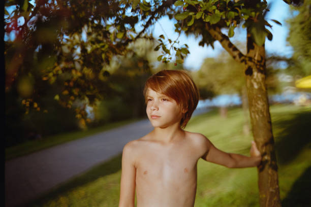 Thoughtful elementary boy in the park. Shoot with Leica M6.