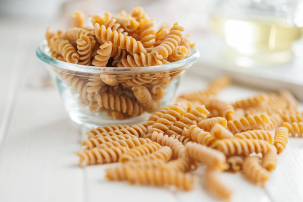 Uncooked whole grain pasta. Raw fusilli in a bowl.