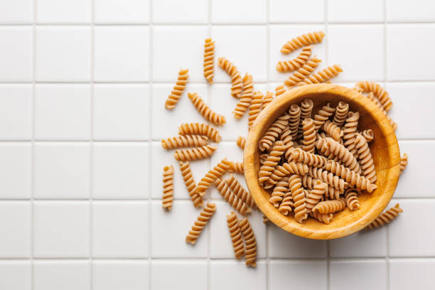 Uncooked whole grain pasta. Raw fusilli in bowl.