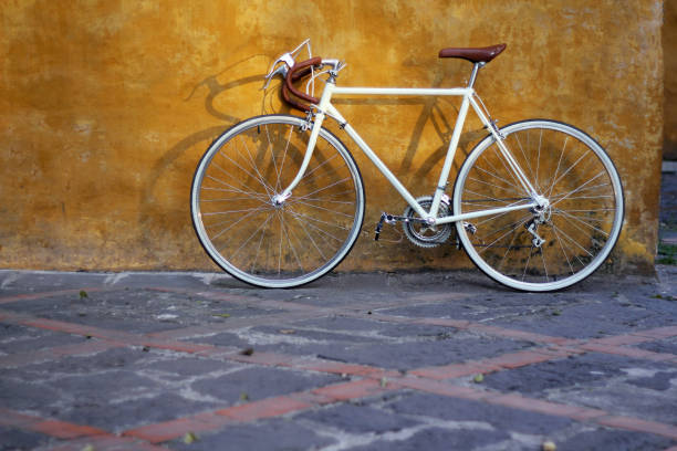 istock White retro road bicycle in front of yellow wall 2163551284