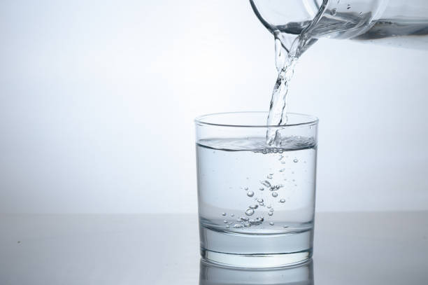 istock Drinking water is poured into a glass from a jug 2163551434