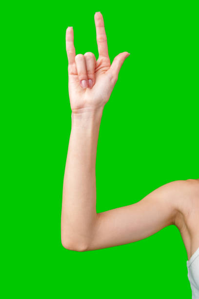 istock Woman's Hand Making Rock And Roll Sign Against Green Screen 2163552108