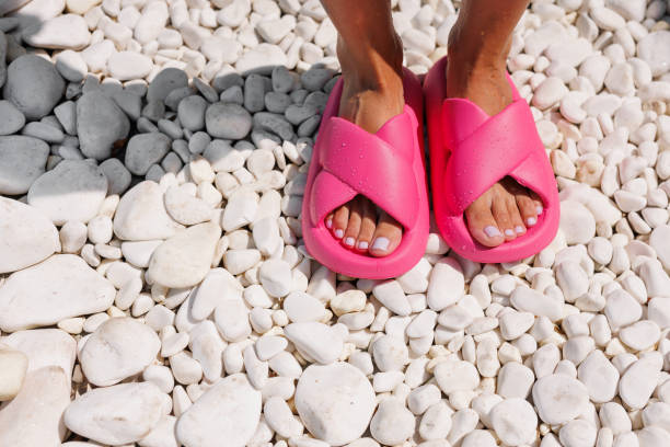 istock Bright Pink Sandals on White Pebbles 2163553005