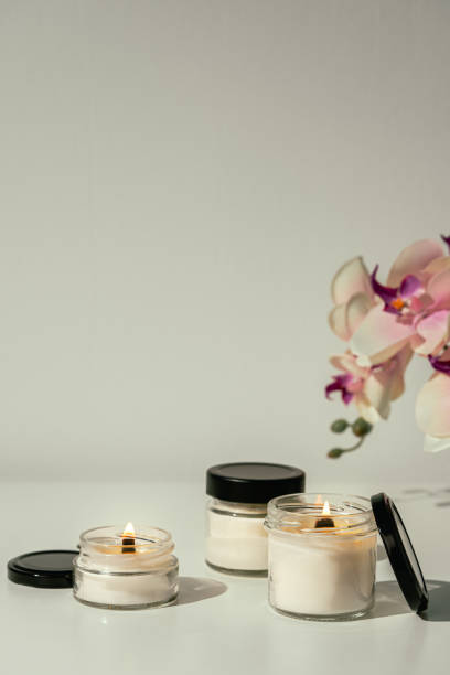istock Burning Candles With Pink Orchid Flowers on White Surface 2163553381