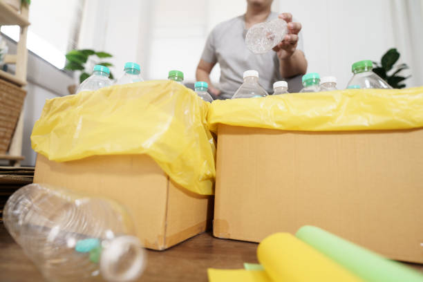 istock Home recycle eco green zero concept Man throwing empty plastic bottle in recycling bin with yellow garbage bags at home 2163553509