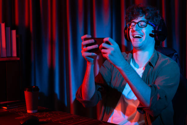 istock Smiling streamer team playing with Esport online on smartphone. Gusher. 2163554124