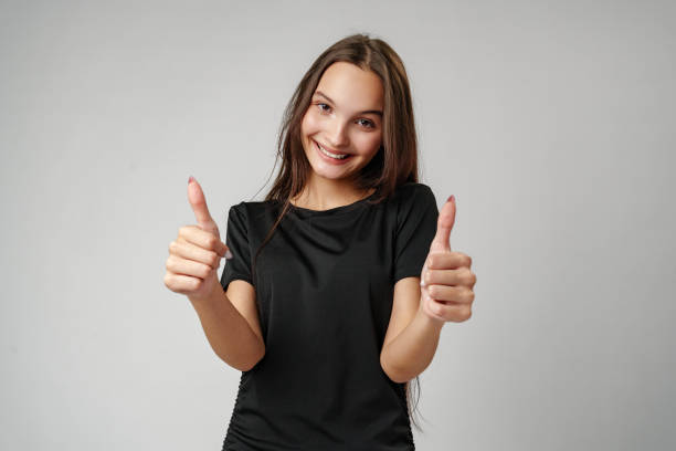 istock Young Woman Giving Thumbs Up in Studio 2163558366