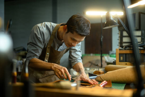 istock Handsome asian craftsman working meticulously in a workshop. Small business and handmade concept 2163558622