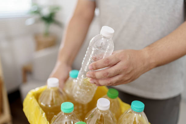 istock Home recycle eco green zero concept Man throwing empty plastic bottle in recycling bin with yellow garbage bags at home 2163559733