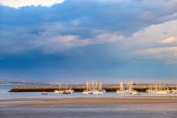 Boats in a marina with thunderclouds on the sky in evening light
